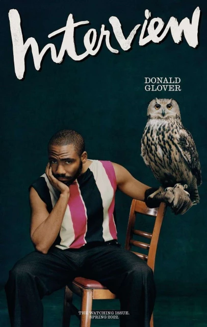 Interview magazine cover featuring Donald Glover seated with a Eurasian eagle-owl, set against a dark green backdrop in a portrait-style.