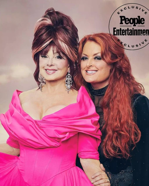 Two women, Wynonna Judd and her mother Naomi Judd, pose together in formal attire, with a logo for People Entertainment.