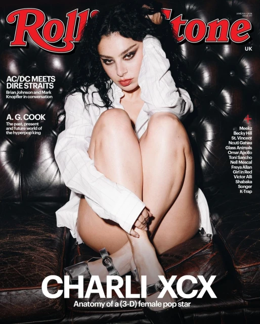 Charli XCX graces the cover of Rolling Stone UK. She sits on a dark leather couch, gazing at the camera while wearing a white shirt.