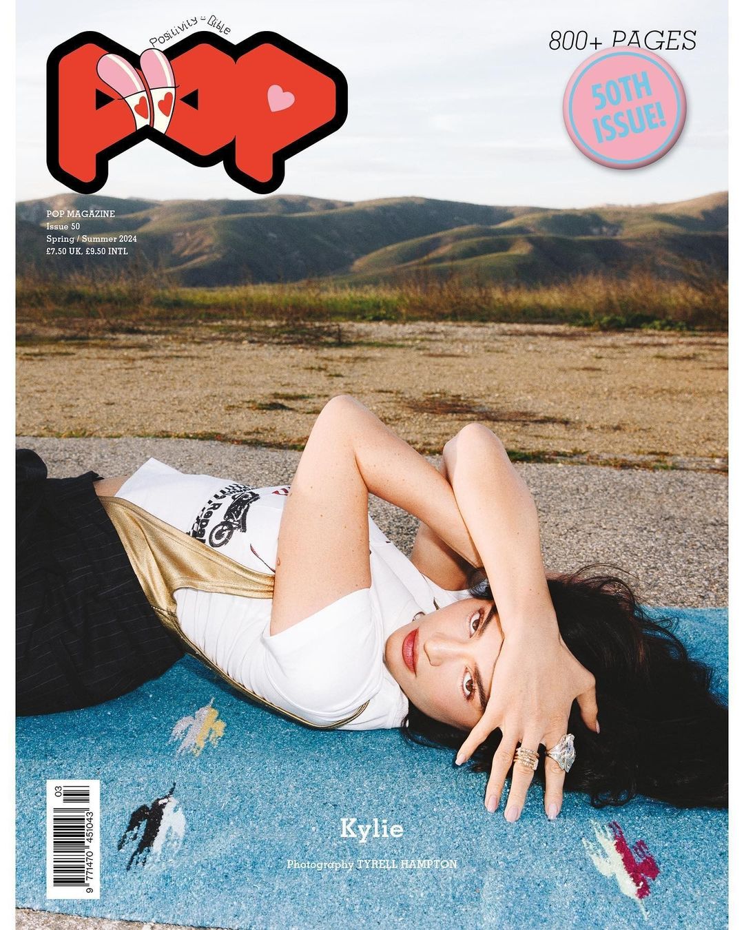 Magazine cover featuring a woman lying on a patterned surface in front of a blurred landscape, with 'POP' logo and cover text.