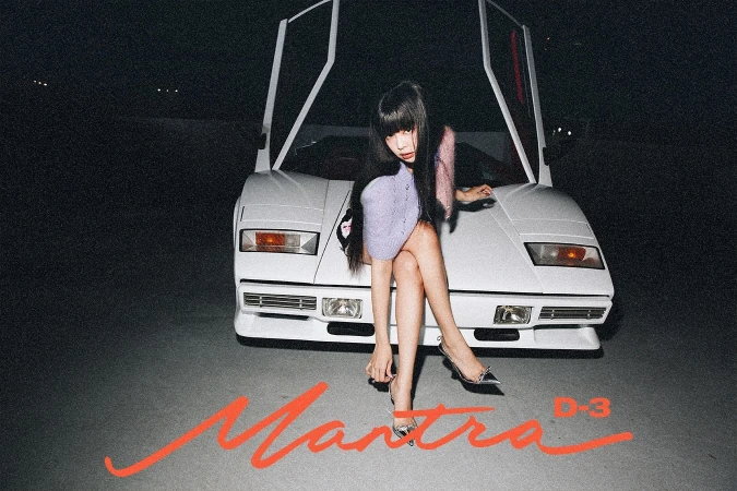 Young woman poses in front of a vintage white sports car at night, wearing a lavender dress and silver heels. Studio shot.