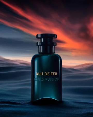 A sleek, dark perfume bottle by Louis Vuitton is centered against a gradient sky, creating a luxurious and atmospheric product shot.