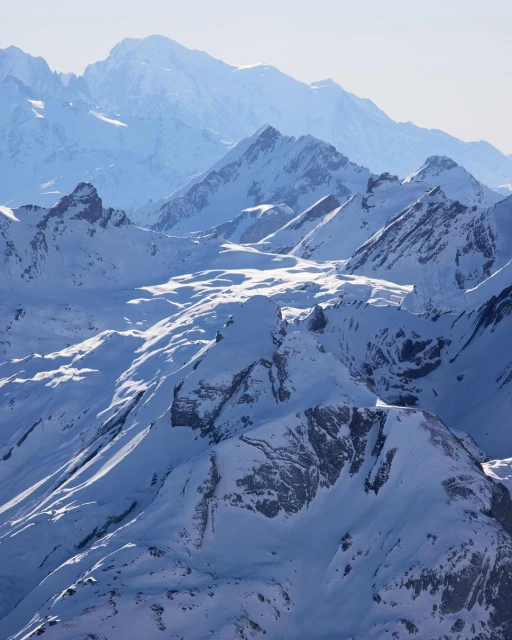 Scenic view of snow-covered mountain range under a clear sky, showcasing natural beauty and winter landscape photography.
