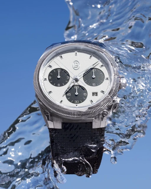 Wristwatch surrounded by water splashes against a blue background, silver case, white dial, black band, luxury, timekeeping.
