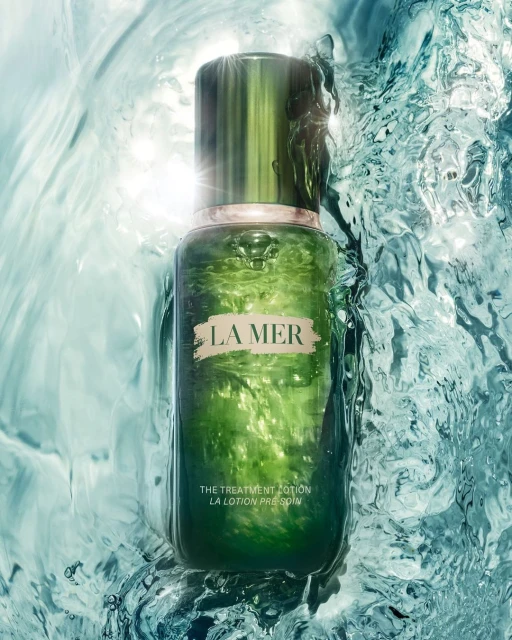 La Mer skincare product bottle in flowing water against a bright background, creating a serene and luxurious beauty advertisement.