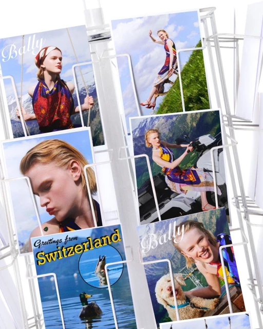 Rack of postcards features a model in a fashion photoshoot backdrop featuring Switzerland's mountains and lakes, plus a dog.