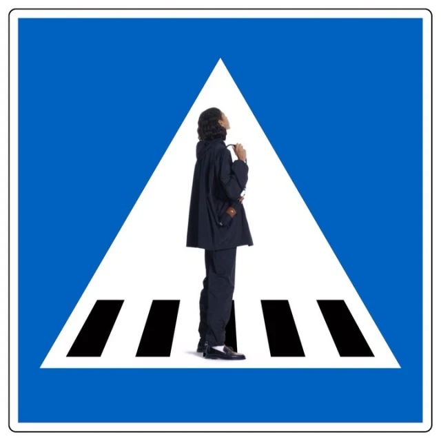 Person in dark suit on pedestrian crossing sign.  Conceptual shot of modern fashion with blue and white graphic design.