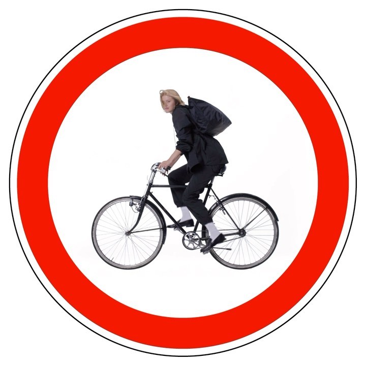 Person riding a black bicycle inside a red circle with a white background, evoking a road sign symbolizing 'no bicycles allowed'.