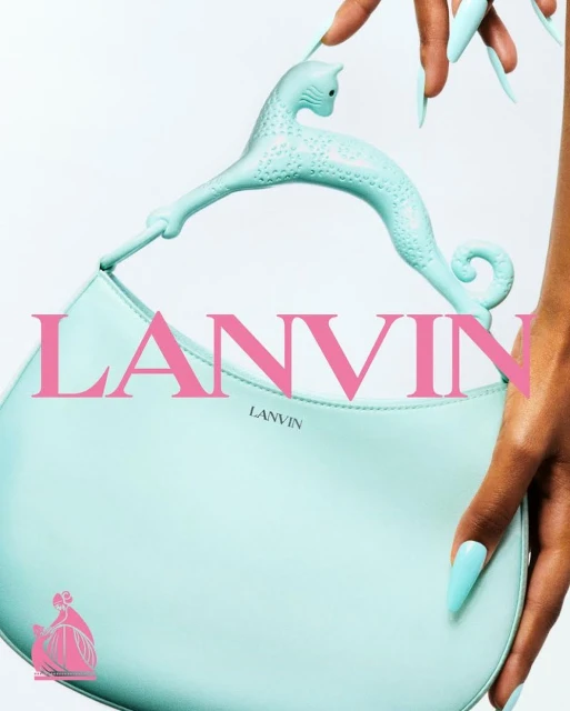 Lanvin mint-green purse with cat-shaped handle held by a hand with long, mint-green nails against a light background, pink logo.