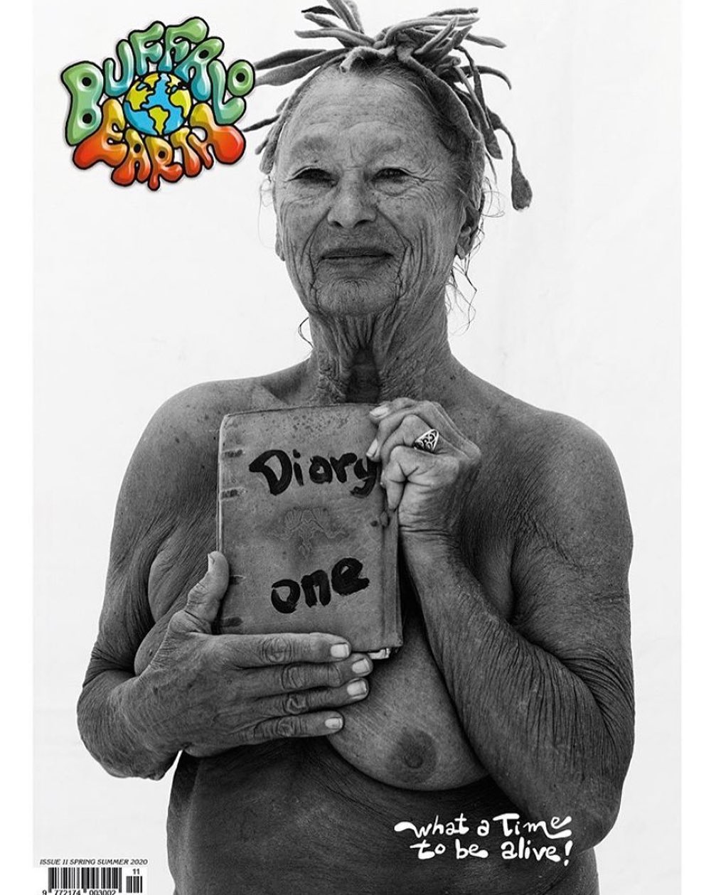 Black-and-white image of an older adult woman with dreadlocks holding a book titled 'Diary one,' with 'Buffalo Earth' logo.