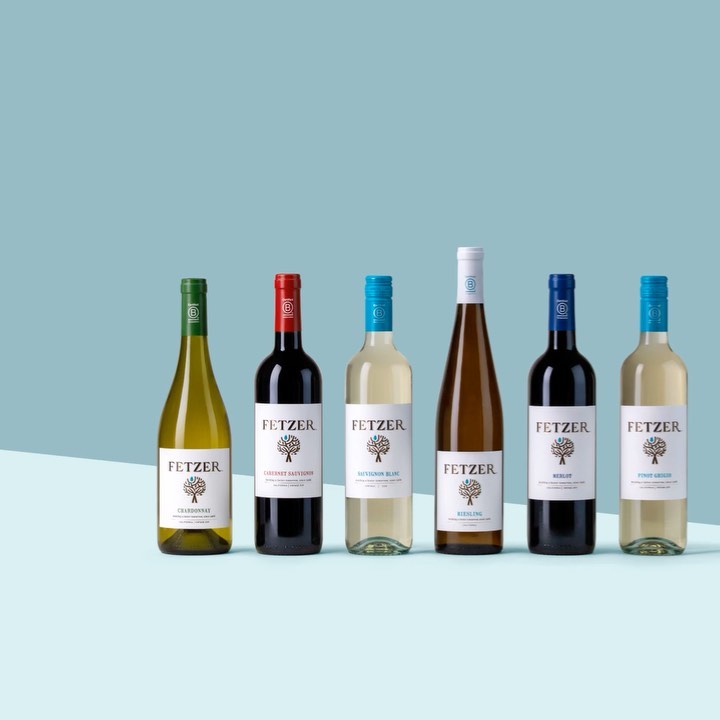 Multiple bottles of Fetzer wine with various labels, standing on a flat surface against a gradient blue background in a studio setting.