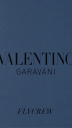 Dark blue surface featuring uppercase black text reading VALENTINO GARAVANI and FLYCREW below.