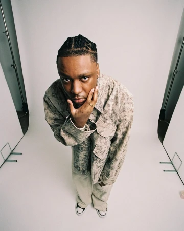 Man wearing patterned patterned shirt leaning forward in studio by Vicky Grout