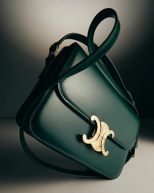 Studio shot of a green leather purse with a gold logo, showcasing its design and high-end craftsmanship against a neutral background.