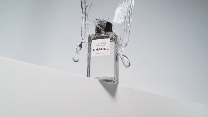 Chanel L'HUILE ORIENT Corps-Body perfume bottle on white surface with splashing water for beauty or fashion advertising.
