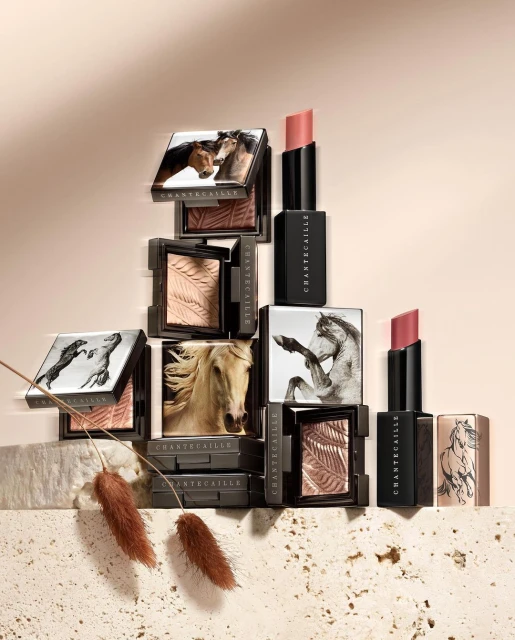 Cosmetic products by Chantecaille featuring lipsticks and eyeshadow palettes adorned with horse imagery in a styled product shot.
