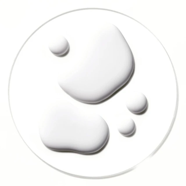 Close-up of several drops of white liquid arranged on a clear surface, creating an abstract and minimalist composition.