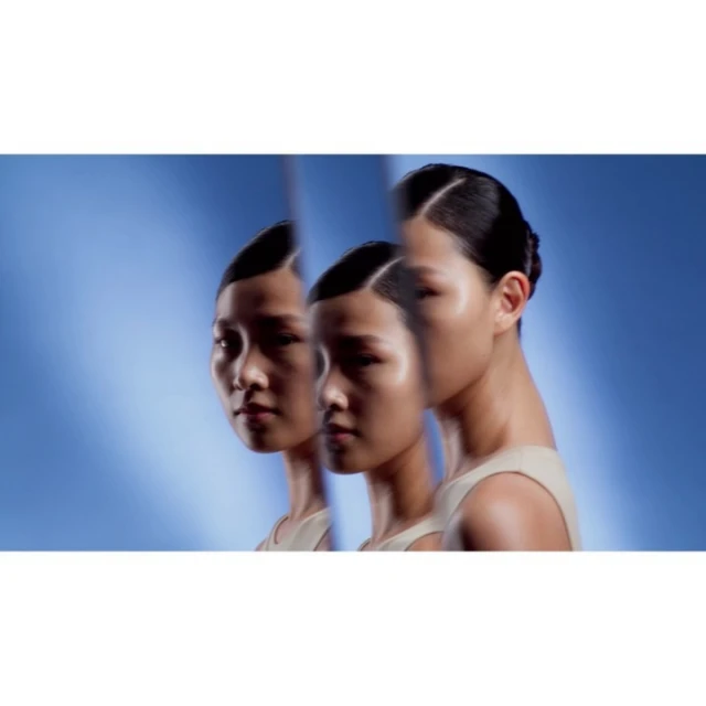 Multiple exposure effect featuring a woman with dark hair and light skin against a diffused blue backdrop. Beauty and fashion themes.