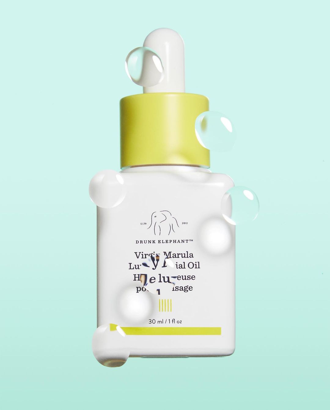 Drunk Elephant Virgin Marula Luxury Facial Oil product shot, showcasing the minimalist white bottle, yellow cap, and clear droplets.