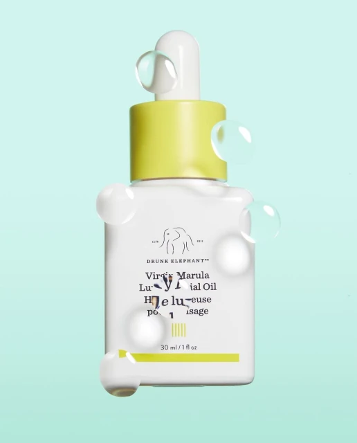 Drunk Elephant Virgin Marula Luxury Facial Oil product shot, showcasing the minimalist white bottle, yellow cap, and clear droplets.