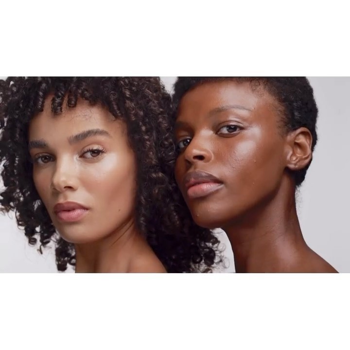 Two women with curly hair pose in a close-up shot. One model has lighter skin and curly hair, while the other model has darker skin.