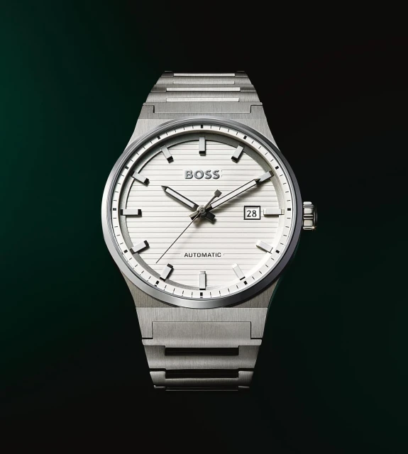 Silver-toned automatic wristwatch with a white face and date window against a dark green background, highlighting its sophisticated design.