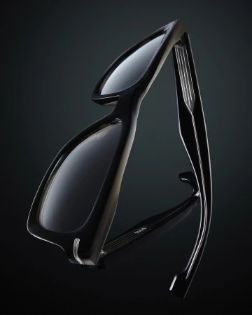 Close-up studio shot of sleek black eyeglasses with a reflective surface against a dark background, emphasizing the design and materials.