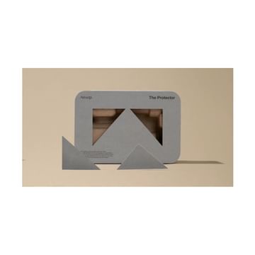 Aesop packaging with triangular design elements on a beige surface, showcasing minimalist aesthetic and product presentation in a studio shot.