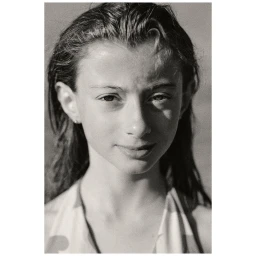 Close-up black and white portrait of a young person with wet dark hair looking directly at the camera.
