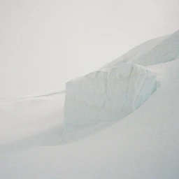 Minimalist view of an ice crevasse with stark white and pale blue glacial walls under soft light.