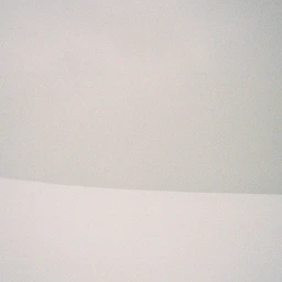 Minimalist composition showing a curved horizon line separating a plain white surface and a soft grey background.
