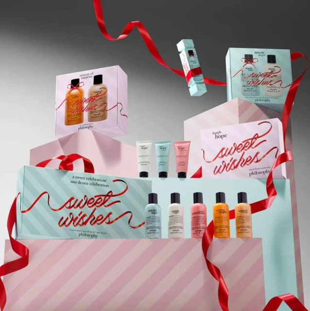 Stacked product photography of Philosophy brand skincare gift sets with ribbons and pastel colors against a grey studio backdrop. 