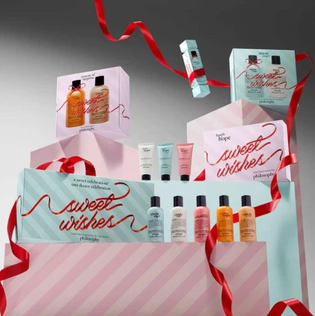 Stacked product photography of Philosophy brand skincare gift sets with ribbons and pastel colors against a grey studio backdrop. 