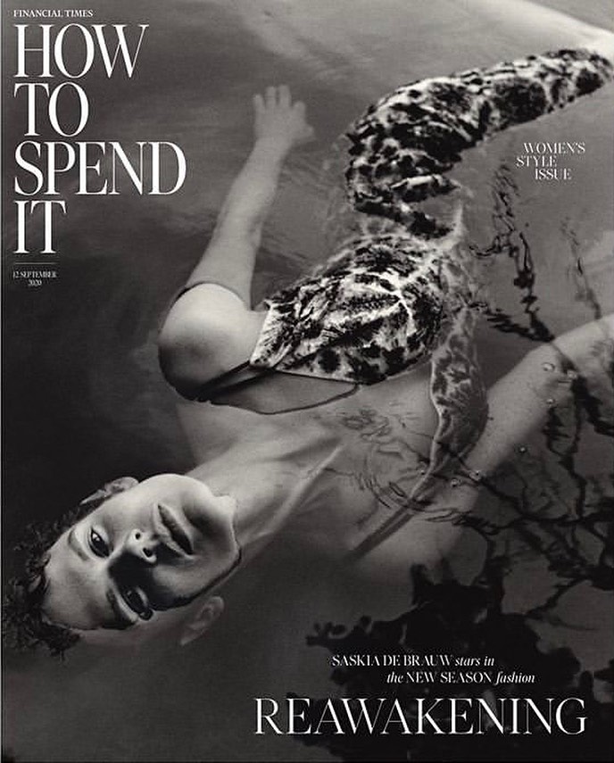 Fashion magazine cover featuring a woman with a patterned swim cap, submerged in water in a black and white photograph.