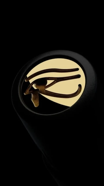Close-up studio shot of an earbud featuring a gold Eye of Ra emblem against a sleek black backdrop, showcasing modern technology.