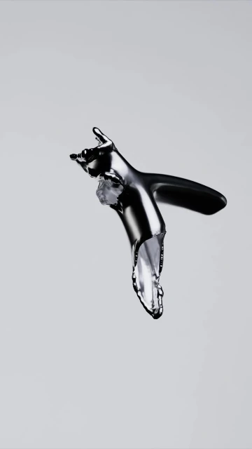 Chrome faucet in a studio shot with water dripping out of the tap against a gray background, illustrating plumbing concept.