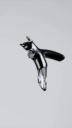 Chrome faucet in a studio shot with water dripping out of the tap against a gray background, illustrating plumbing concept.