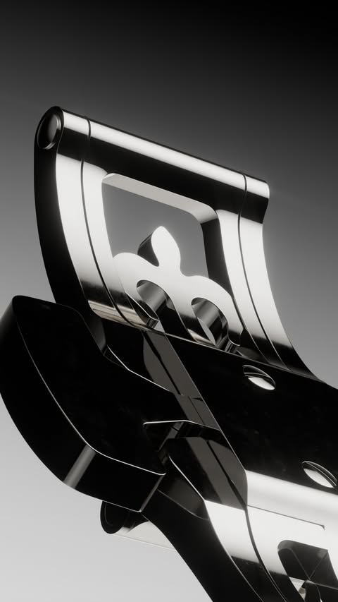 Close-up of a shiny chrome metal decorative piece featuring fleur-de-lis designs against a gradient gray background, showcasing luxury and artistry.