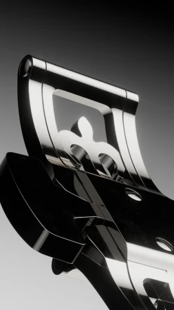 Close-up of a shiny chrome metal decorative piece featuring fleur-de-lis designs against a gradient gray background, showcasing luxury and artistry.