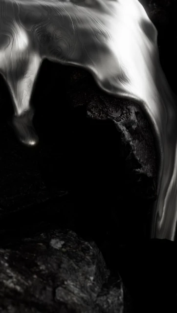 Abstract close-up of textured, rippled rock formation with silver and grey tones against a contrasting black background.