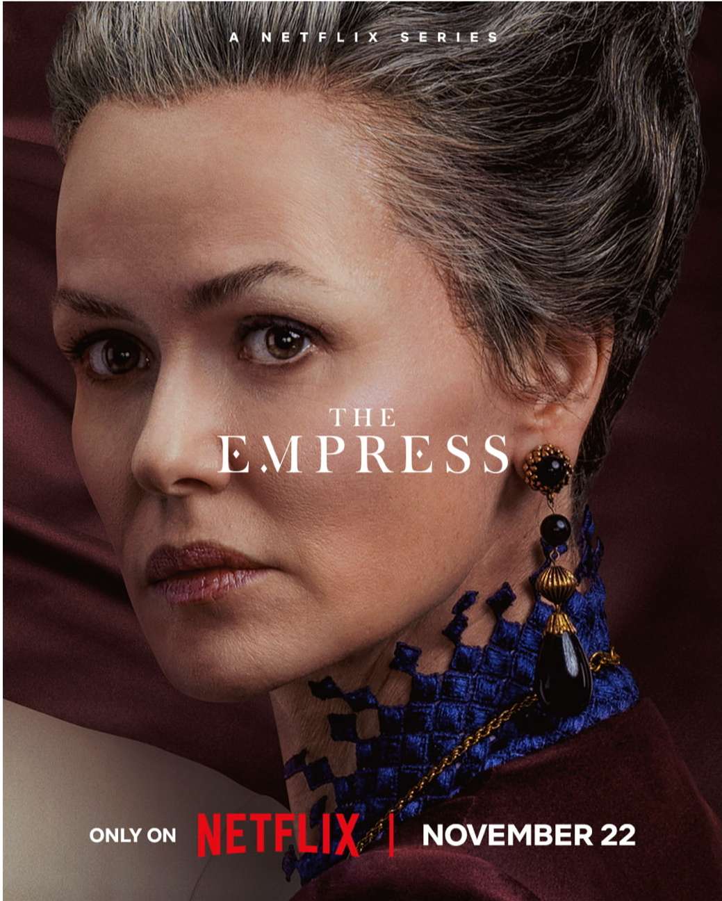Promotional poster of adult female with gray hair wearing an elegant gown with jewelry for the Netflix series, The Empress.