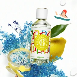 Fragrance bottle surrounded by blue dried flowers, a yellow lemon, and a stylized swimmer illustration by Virginie Morgand