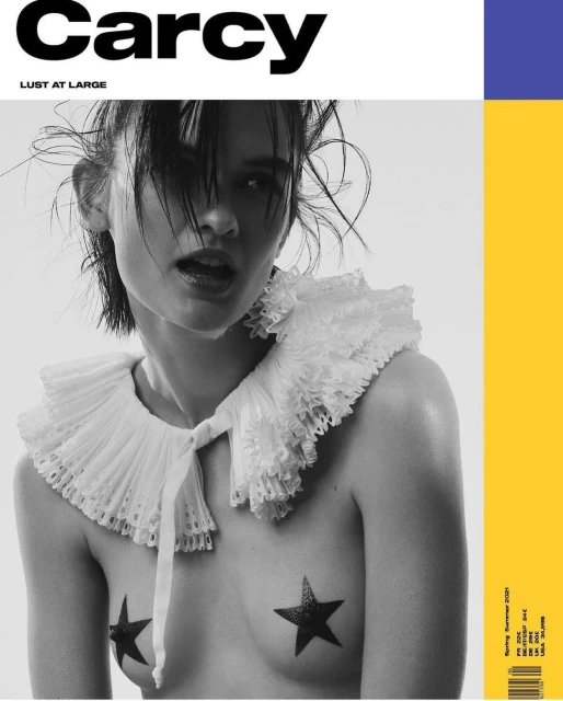 Black and white magazine cover featuring a woman with short hair, wearing a lace collar, and star-shaped pasties against a bright background.