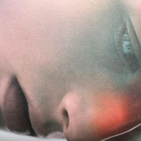 Close-up portrait of an individual's face featuring skin texture, a single eye, and subtle red and green color grading.