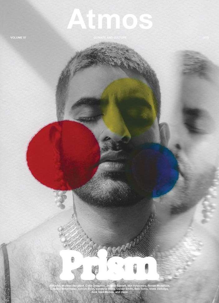 Black and white magazine cover featuring an androgynous model wearing pearl earrings and a choker necklace with primary colored circles.