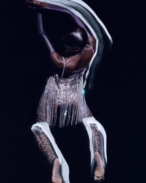 Woman in rhinestones poses in studio. Elegant fashion photograph shows adult female in shiny dress and leggings on dark background.