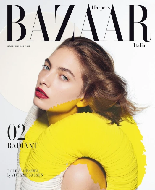 Harper's Bazaar Italia cover featuring a model with red lipstick, brown hair and yellow paint accents on a white background.