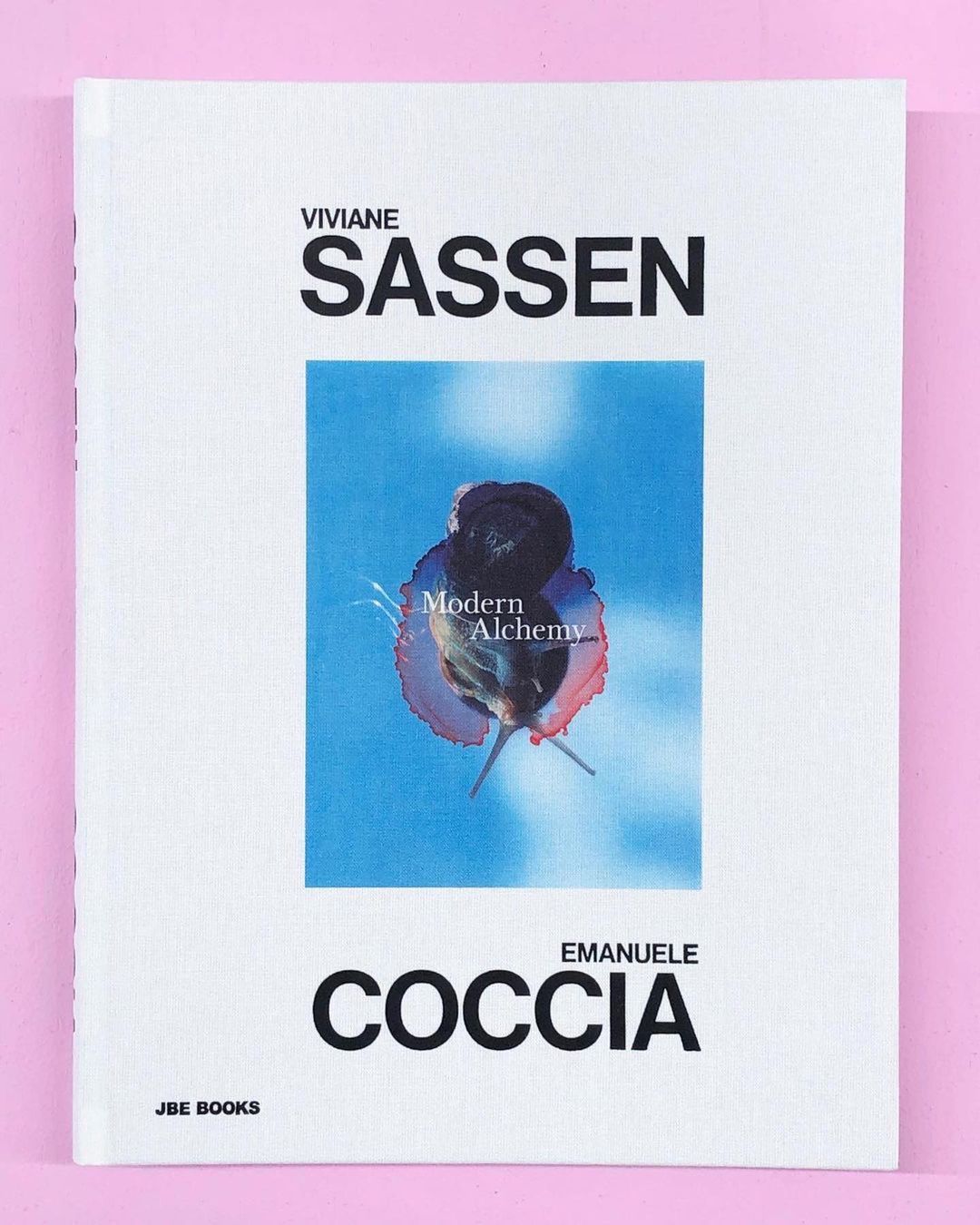 The cover of the book 'Viviane Sassen, Emanuele Coccia, JBE BOOKS' features a blue-toned image with the words 'Modern Alchemy'.