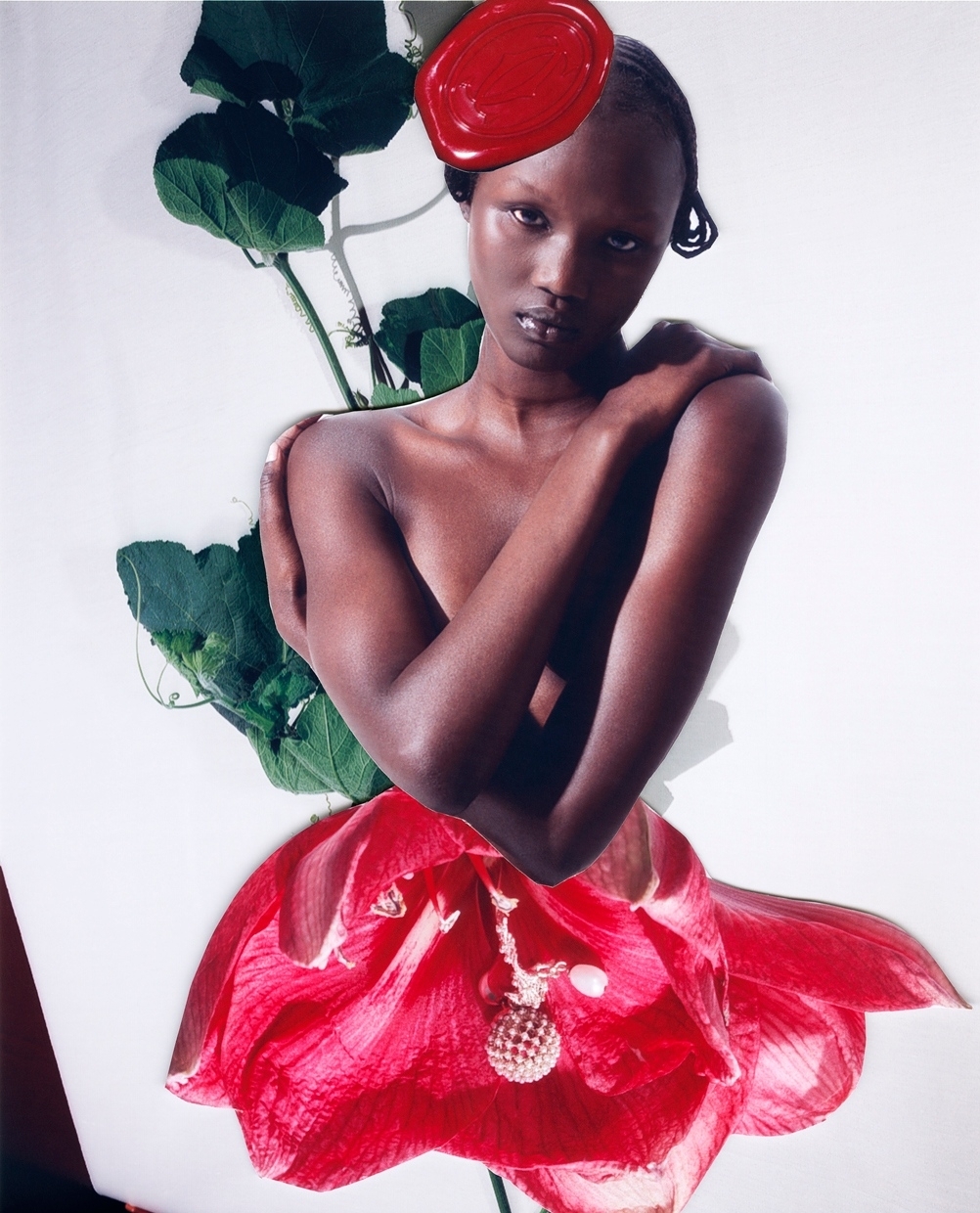 Striking fashion portrait of a Black woman with a red headpiece and flower dress, posing in a photo studio against a bright white background.