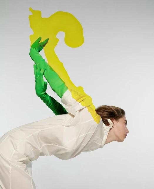 Woman in white dress and rubber gloves with yellow overlay in studio. Side view. Creative fashion and beauty photography.